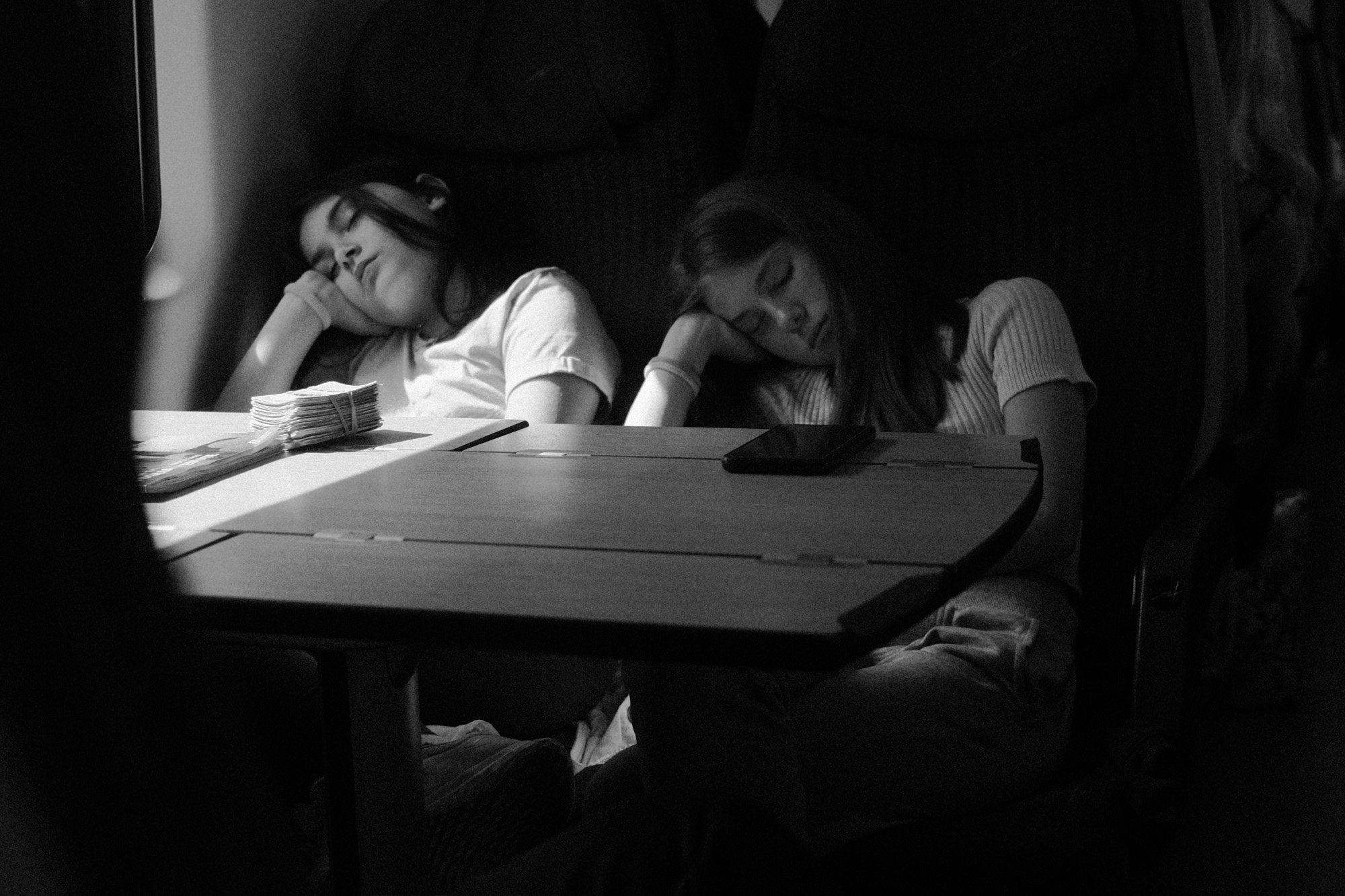 Black-and-white documentary photograph of children drawing at a table.