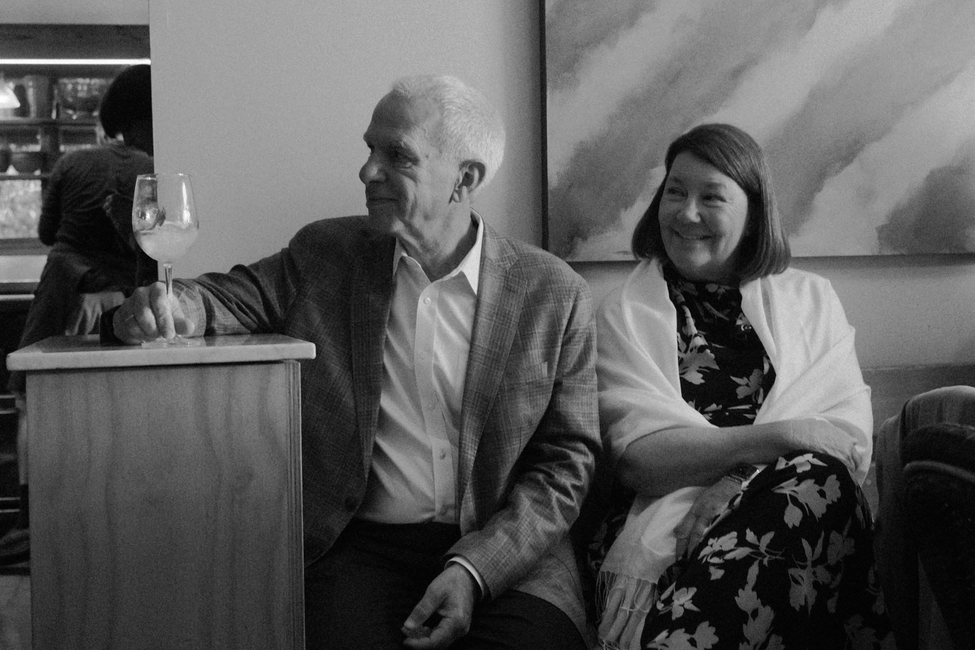 Black-and-white portrait of a seated couple near a window.