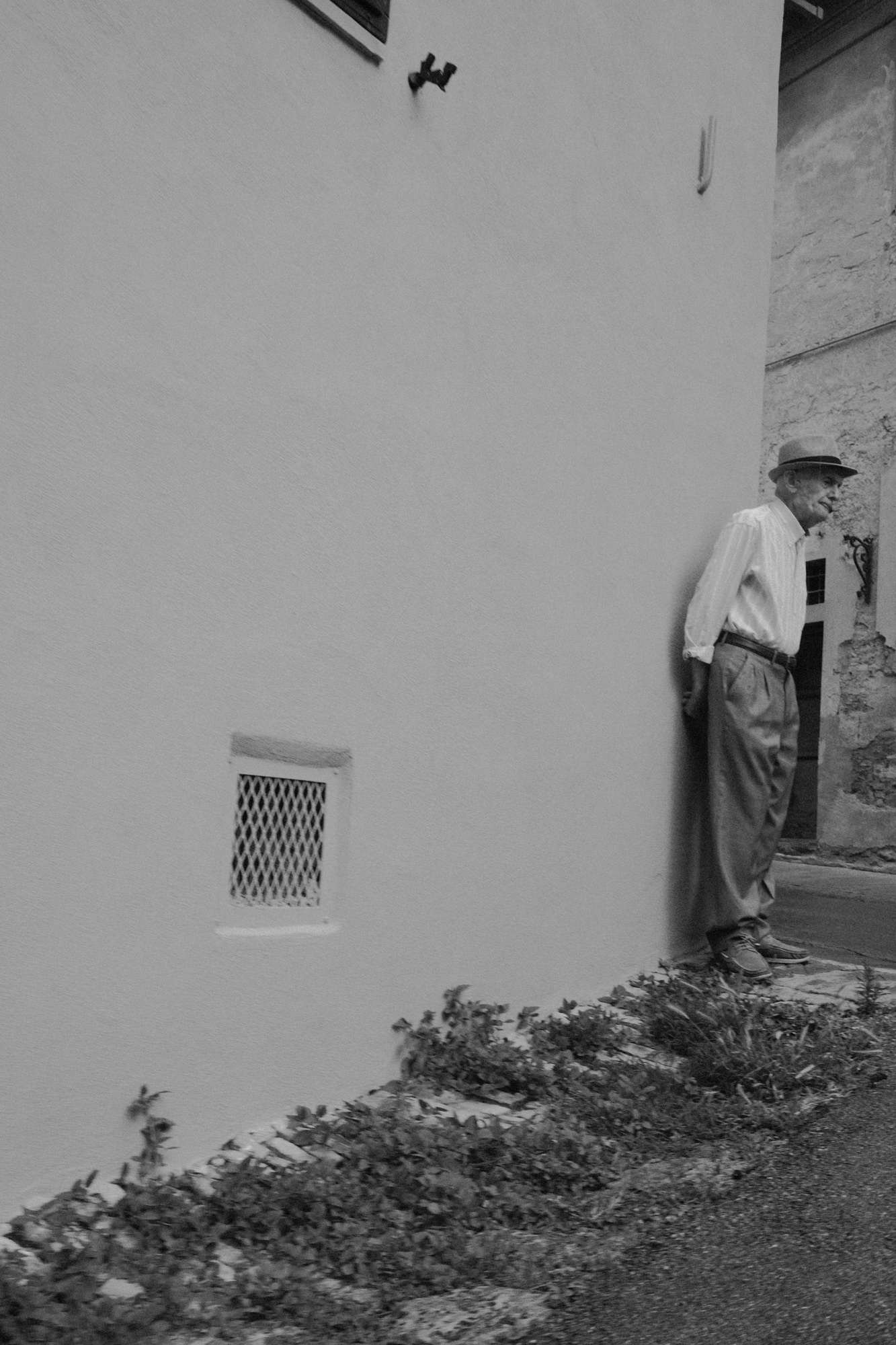 Black-and-white photograph of a figure beside a white wall from Seeking Grace.