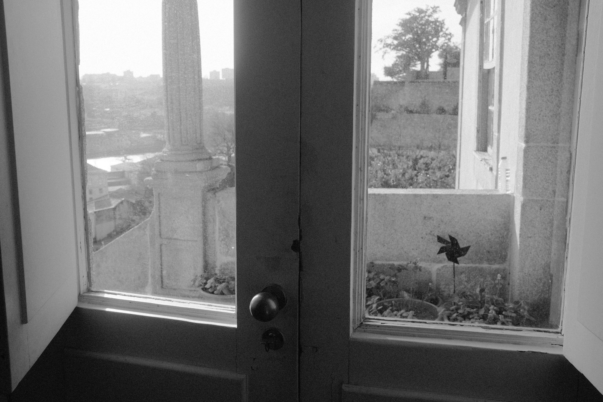 Black-and-white photograph of a view through a window in a place of meaning.