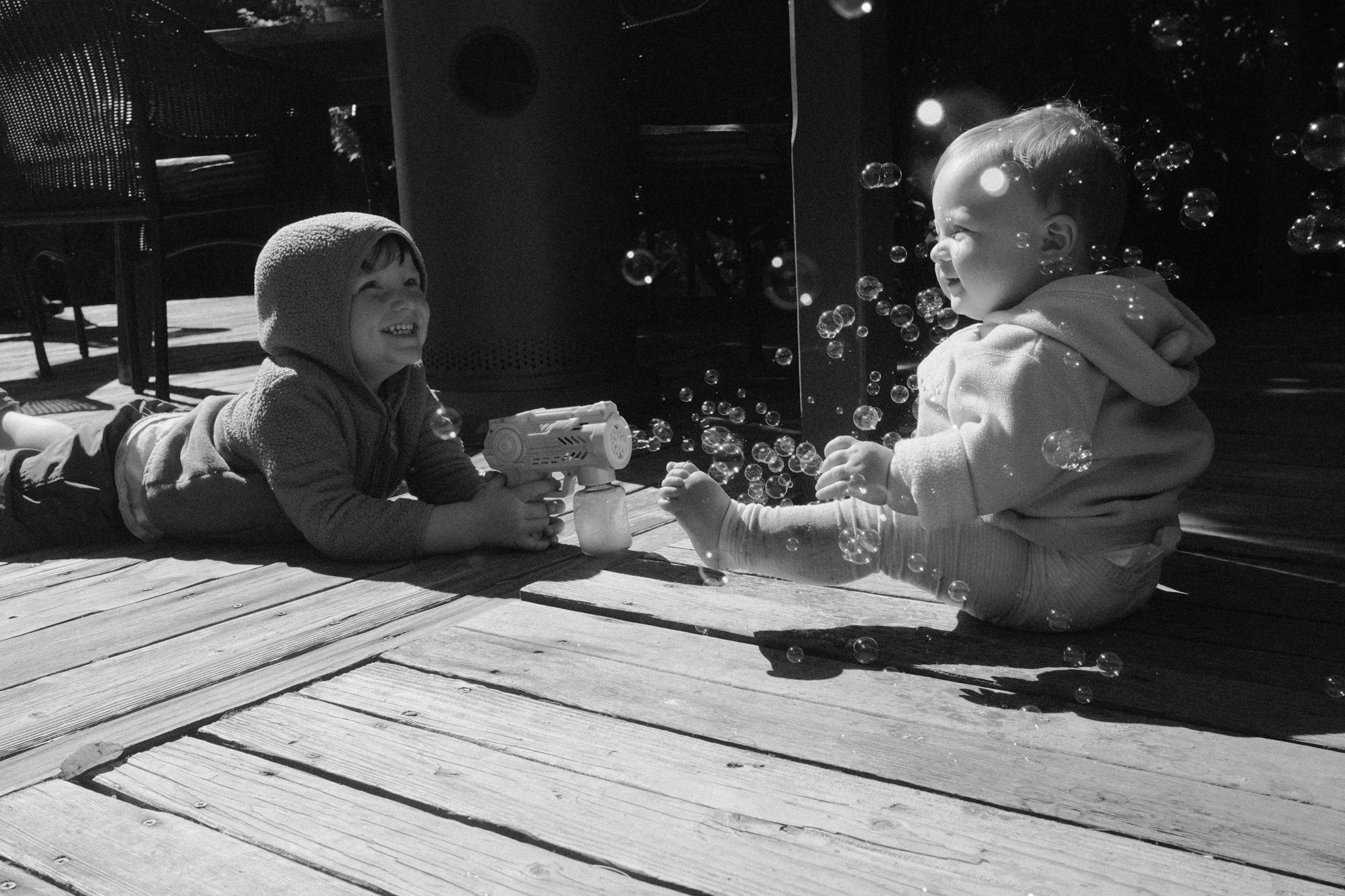 Black-and-white documentary photograph of children gathered at a table.